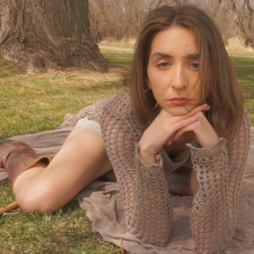 Monalisa Perez poses under a tree staring into the camera.